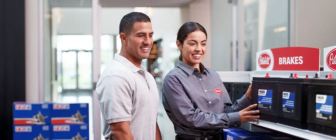 A Peterbilt clerk explains a part to a customer in a dealership