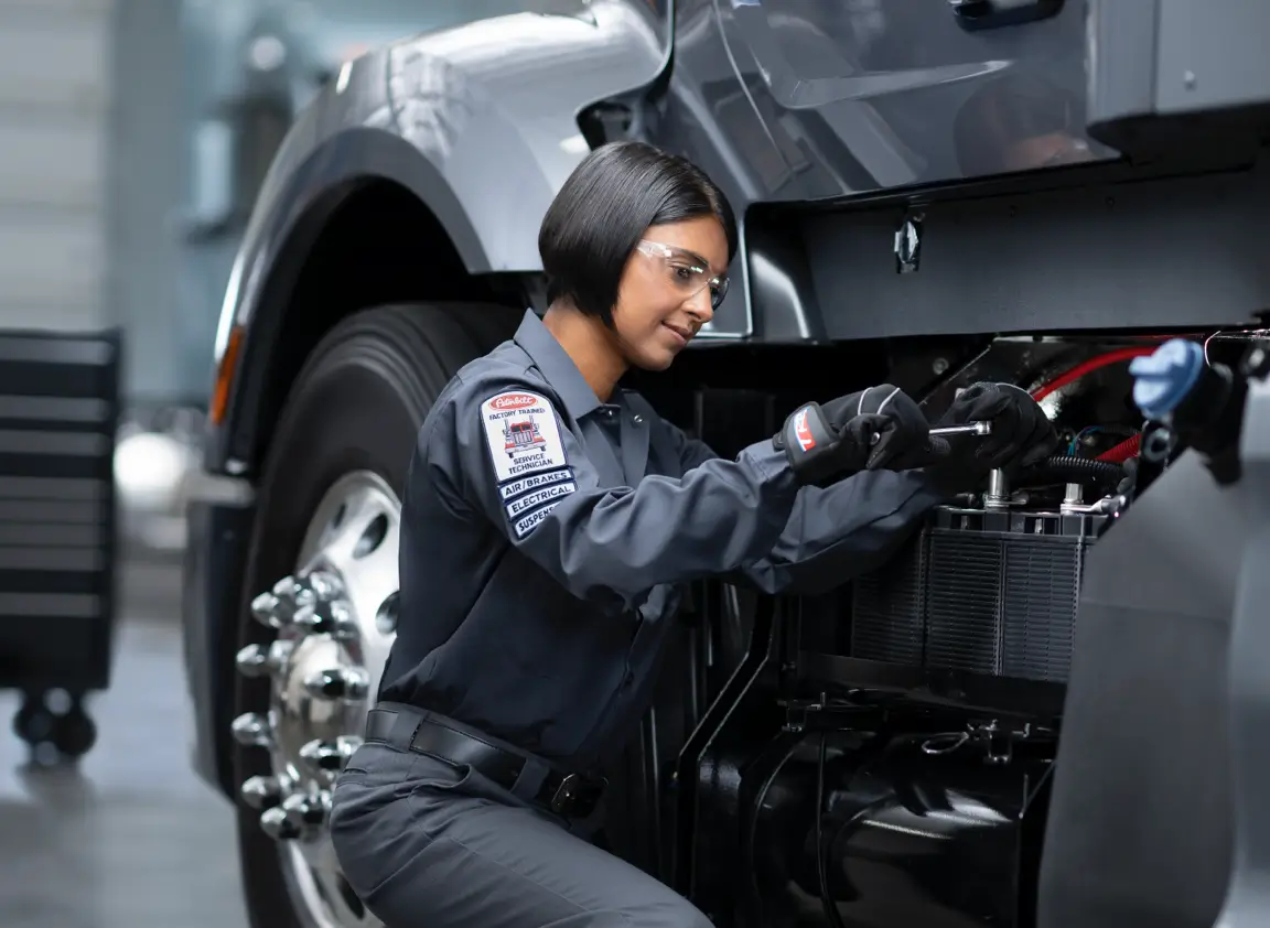 A technician services a Peterbilt truck